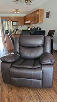 Front view of dark brown vinyl recliner showing padded seat, back cushions and armrests