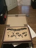Open box displayed on floor showing 'Royal Artillery' label on lid.