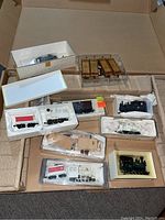 Overview photo of all seven model train cars and accessories in the box including foam trays and plastic display boxes