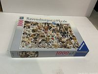 Photo of Ravensburger 1000 piece jigsaw puzzle box showing image of dog collage on front.