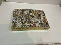 Box of unopened 500 piece animal jigsaw puzzle showing collage of various animal pictures on lid.