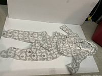 Pajama set laid flat showing the full outfit: button-up, long-sleeve top and footed pants with animal pattern