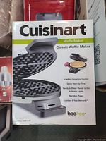 Photo of the Cuisinart waffle maker original retail box showing the product image, model number, and key features.