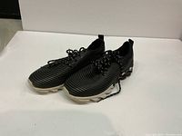 Pair of Fashion Tubular womens running shoes side view showing black and white stripes and lace-up design.