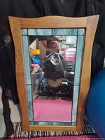 Full view of the rectangular wooden framed mirror with light blue stained glass border showing the mirror reflection.