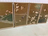 Four bamboo-framed oriental art panels laid next to each other, showing a continuous nature scene with birds and blossoms.