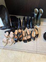 Full view of all nine pairs of women's shoes including boots, sandals, and flats