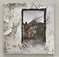 Front cover of Led Zeppelin IV showing peeling wallpaper texture with framed image of a man carrying sticks.