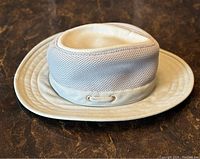 Side angle view of Tilley Endurables mesh hat showing khaki green and beige mesh panels with fabric brim.