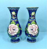Front view of two matching blue cloisonné vases with pink peony flower designs and decorative gold banding.