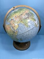 Front angled view showing Asia, Australia, and the metal base with some rust spots.