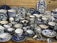 Overall front view of entire assortment showing plates, bowls, jars, cups and saucers