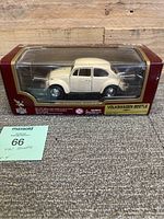 Side view of the die cast Volkswagen Beetle model in original box showing cream/off-white color and packaging condition