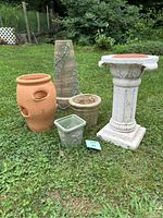All five garden items arranged on grass outdoors showing the variety of planters and pedestal.