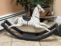 Front side view of the vintage chalkware rocking horse showing horse and black rocker base