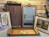 Overview of all items including two wooden trays with floral designs, a vintage wooden framed mirror, and two framed artworks: a print and a watercolor painting.