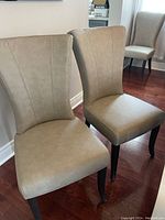 Two chairs angled showing front upholstery and dark wood legs