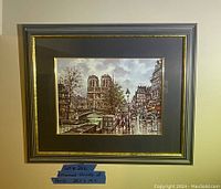 Framed print featuring Notre Dame Cathedral and Seine River scene, professionally matted and framed.