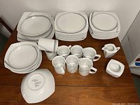Full set of Studio Nova dishes laid out on table showing quantity and condition.