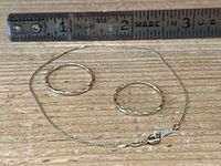 Hoop earrings and bracelet next to a ruler showing scale