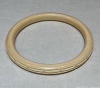 Front view of the carved bangle bracelet showing geometric carved pattern.