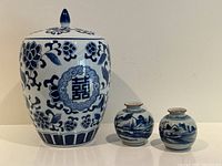 Group view of lidded ginger jar and two small vases