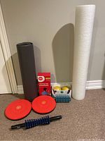 Photo showing entire fitness lot including yoga mat, foam roller, balance wheels, weighted balls, massage roller stick and heating pad