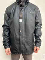 Front view of new black men's leather jacket with tags, zip and snap buttons closed, silver logo visible on chest.