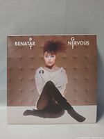 Front cover image of Pat Benatar's Get Nervous vinyl LP showing artist sitting against padded wall background in off-white top and black leggings.