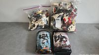 Two large bags containing assorted loose LEGO parts behind two LEGO Bionicle sets in original packaging; the sets are Phantoka #8693 and Stronius #8984
