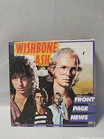 Close-up photo of Wishbone Ash's Front Page News album cover showing band members