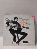 Eric Andersen vinyl LP album titled 'Bout Changes & Things, showing cover art with artist holding an acoustic guitar seated on a stool, monochrome cover with green and orange text.
