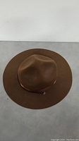 Top down view of the brown Mountie style men's hat showing wide brim and pinched crown with leather band detail.