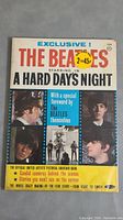 Front cover photo of The Beatles Hard Days Night souvenir book showing band portraits, title text, special foreword mention, and price stickers.