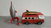 Photo shows all three toys together including the metal van with surfboards and both rocket ships.