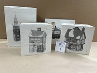 Four original Dept 56 Heritage Village Collection boxes containing ceramic building figurines shown stacked against a neutral background.