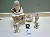 Wide shot showing all items in the lot including the Santa cookie jar, angel figurines, swan basket, snowman, vase, and plaque