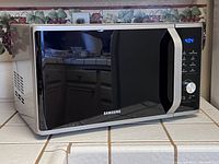Front view of the Samsung microwave oven showing the digital display and control panel.