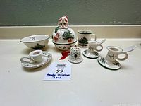 Photo of full set including Santa head container, mug, bowl, bell ornament, candle holders, and small plate.