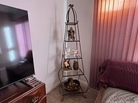 Full view of the vintage metal etagere plant stand with decorative items on it (not included).