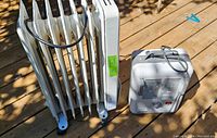 Both heaters side by side on wooden deck floor, Delongi oil heater with multiple fins and electric fan heater with vent and handle visible