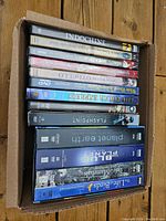Photo showing a top view of the box of DVDs with visible titles including Indochine, Othello, Flashpoint, The Polar Express, The Blue Planet, Planet Earth, Life of Birds, and others.