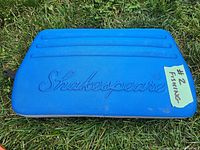 Blue plastic carrying case with Shakespeare embossed logo on top, sticker reading '#2 Fishing'