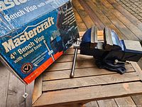 Mastercraft 4-inch bench vise alongside its original blue and red box showing product name and image.