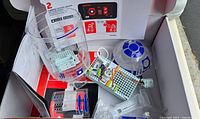 Photo of Star Wars R2-D2 dome, electronic breadboard with wires, mBot Ranger wheels, and parts in box with manuals