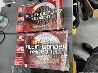 Two boxed ATI All-In-Wonder Radeon graphics cards, models 7500 and 8500DV, stacked on a table.