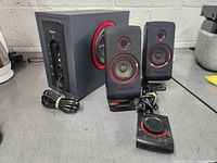 Full system including subwoofer, two satellite speakers, and wired volume control