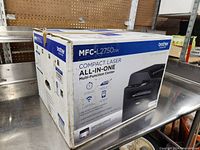 Angled view of the sealed retail box on metal table against pegboard background