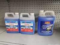 Front view of three 1-gallon cleaning product containers; two Wet & Forget and one Simoniz.