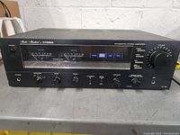 Front view of the Fisher Studio Standard integrated stereo amplifier showing power level meters, control knobs, and buttons.